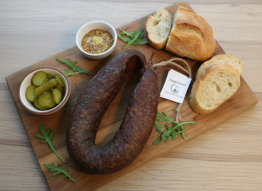 Ziegensalami mit Senf, Gurken und Brot.